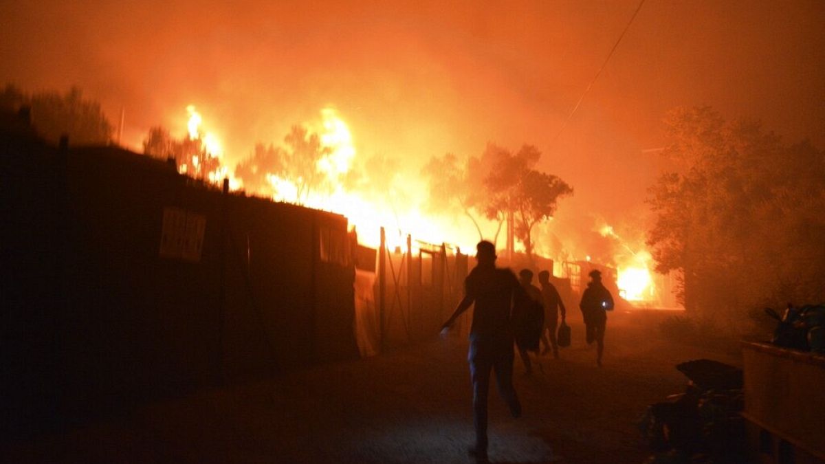 Refugees and migrants run as fire burns in the Moria refugee camp on the northeastern Aegean island of Lesbos, Greece, on Wednesday, Sept. 9, 2020.