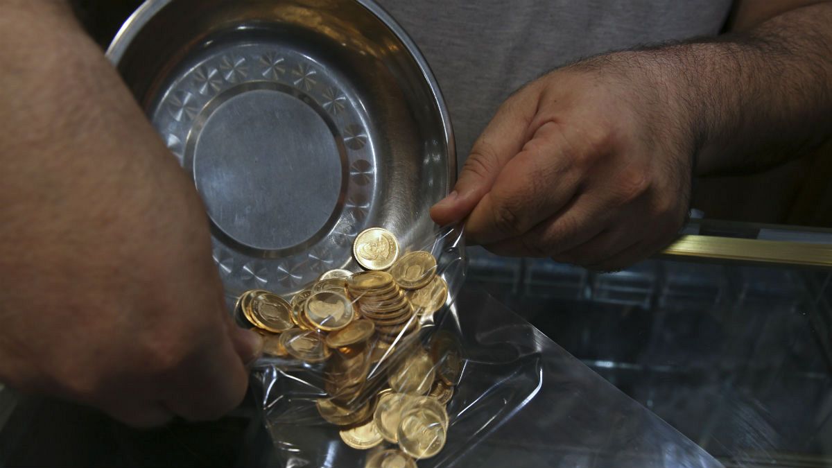  Iranian goldsmith counts gold coins in the sprawling Grand Bazaar
