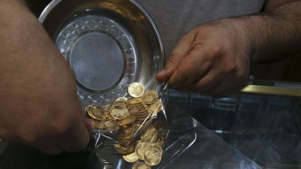 Iranian goldsmith counts gold coins in the sprawling Grand Bazaar Iranian goldsmith counts gold coins in the sprawling Grand Bazaar