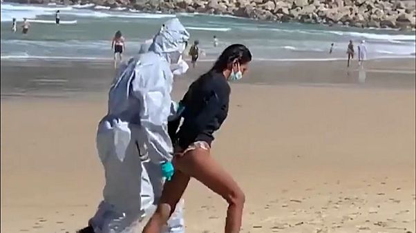 Momento en el que la detenida es sacada de la playa con las manos esposadas en la espalda Momento en el que la detenida es sacada de la playa con las manos esposadas en la espalda