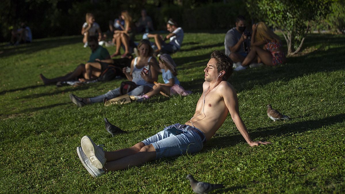 La gente toma el sol en el parque del Retiro en Madrid, España, el viernes 28 de agosto de 2020.