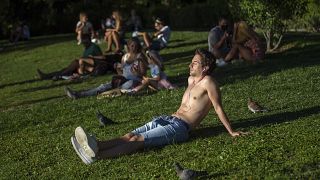 People sunbathe in the Retiro park in Madrid, Spain, Friday, Aug. 28, 2020.