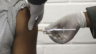 FILE - In this Wednesday, June 24, 2020 file photo, a volunteer receives an injection at the Chris Hani Baragwanath hospital in Soweto, Johannesburg. 