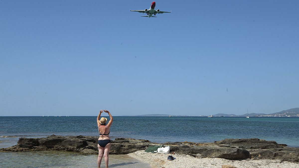 Una turista observa un avión en Palma de Mallorca, España