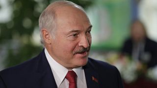 Belarusian President Alexander Lukashenko smiles after voting at a polling station during parliamentary elections, in Minsk, Belarus