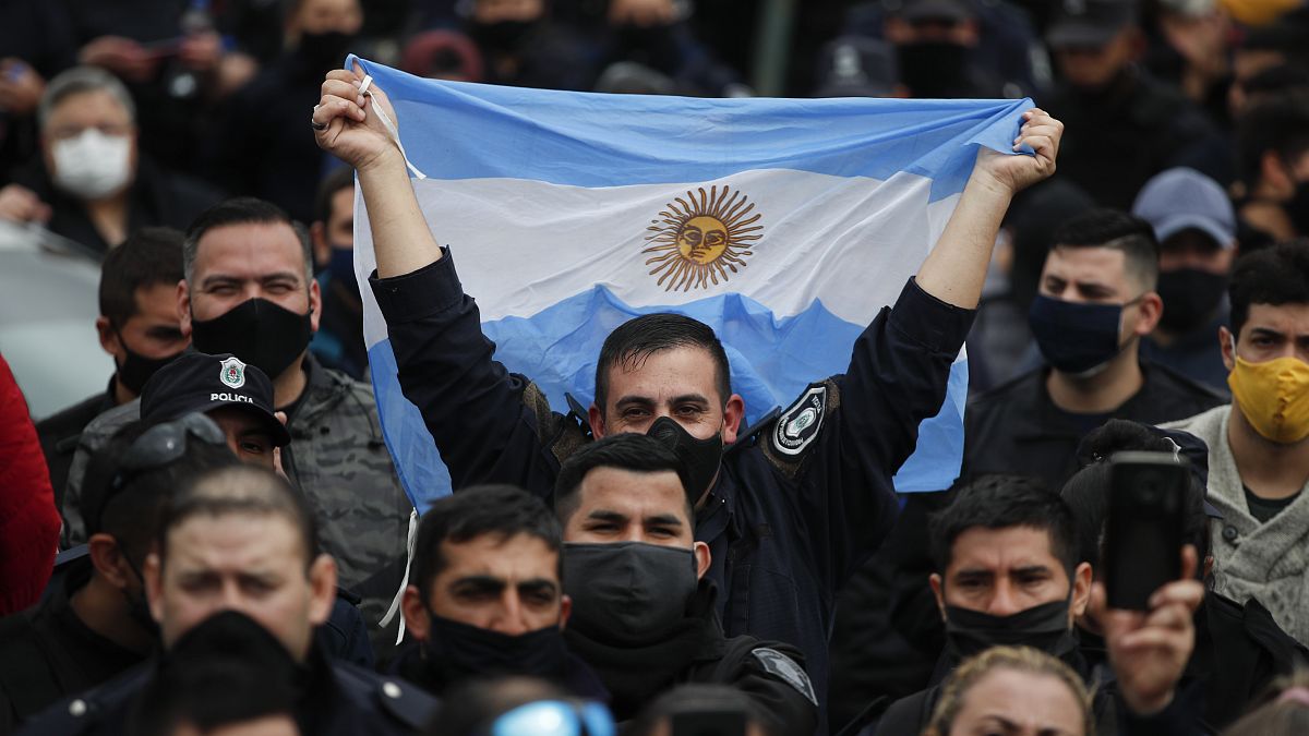 Un policía bonaerense alza una bandera de Argentina durante las protestas