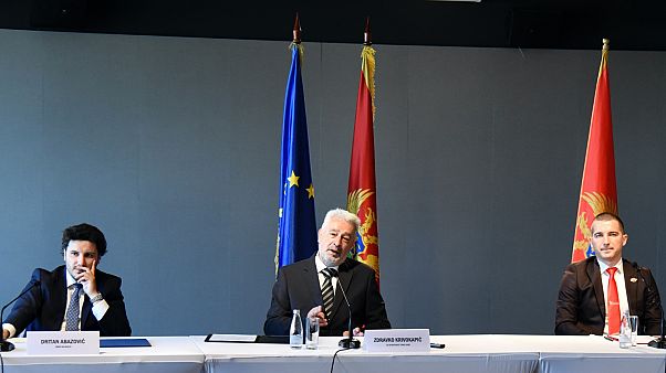 A Montenegró Jövőjéért elnevezésű koalíció vezetői az uniós zászló előtt – középen Zdravko Krivokapić A Montenegró Jövőjéért elnevezésű koalíció vezetői az uniós zászló előtt – középen Zdravko Krivokapić