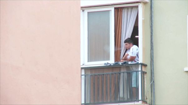 Un joven fuma un cigarro en el balcón de su casa en uno de los barrios que ha entrado en cuarentena Un joven fuma un cigarro en el balcón de su casa en uno de los barrios que ha entrado en cuarentena