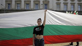 File photo: A protester holds a giant Bulgarian flag during the 64th day of protests in front of the new National Assembly building, in Sofia, Bulgaria. Sept. 10, 2020.