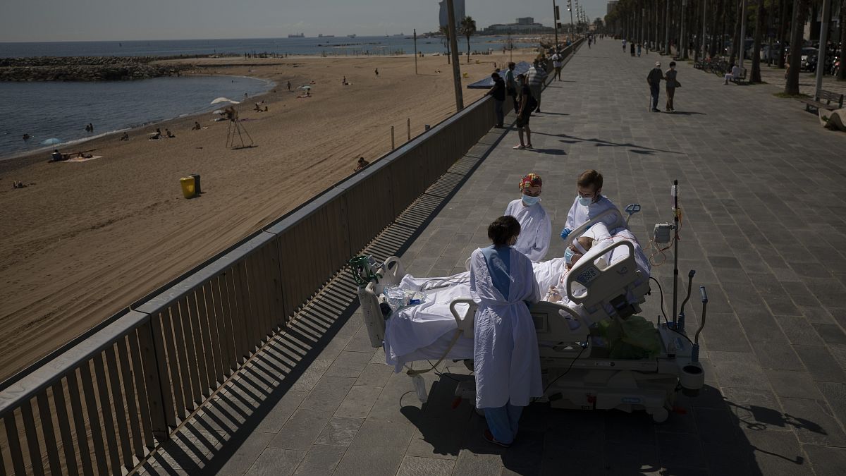 یک بیمار مبتلا به ویروس کرونا در اسپانیا که به توصیه پزشکان مدتی به کنار ساحل منتقل می‌شود