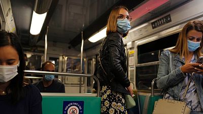 Women stand in a suburb Paris metro train wearing a protective face mask as a precaution against the coronavirus in Paris, Saturday, Sept. 5, 2020.