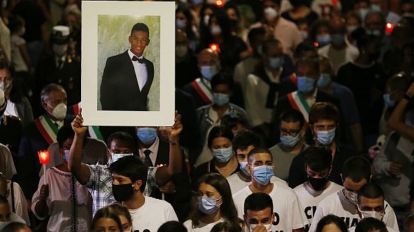 A man holds up a picture of Willy Monteiro Duarte during a torch light procession in Paliano, Italy, on September 9, 2020 A man holds up a picture of Willy Monteiro Duarte during a torch light procession in Paliano, Italy, on September 9, 2020