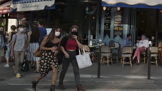 People, wearing a protective face mask as a precaution against the coronavirus, walk in Paris, Thursday Sept. 10, 2020.