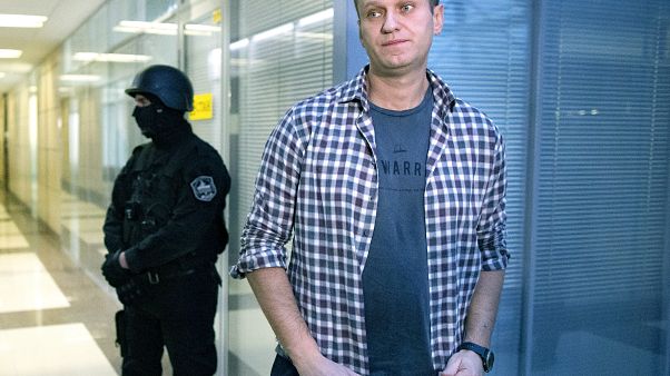 In this Dec. 26, 2019, file photo, Russian opposition leader Alexei Navalny speaks to the media in front of a security officer In this Dec. 26, 2019, file photo, Russian opposition leader Alexei Navalny speaks to the media in front of a security officer