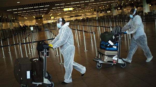 Pasajeros con equipamiento de protección personal completo en el aeropuerto Zaventem de Bruselas Pasajeros con equipamiento de protección personal completo en el aeropuerto Zaventem de Bruselas