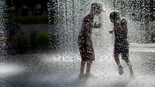 Lithuanian children cool off in a public fountain in Vilnius, Lithuania, Friday, June 19, 2020.