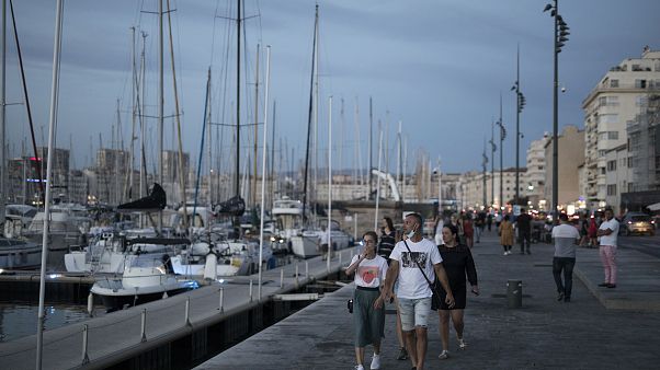 People stroll along Marseille's Old Port, southern France, July 25, 2020. Marseille and Bordeaux are tightening restrictions amid a sharp uptick in coronavirus cases. People stroll along Marseille's Old Port, southern France, July 25, 2020. Marseille and Bordeaux are tightening restrictions amid a sharp uptick in coronavirus cases.