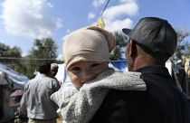 Mann hält Baby im Arm, Moria, Lesbos, 25.9.2020
