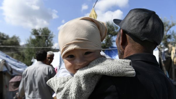 Mann hält Baby im Arm, Moria, Lesbos, 25.9.2020 Mann hält Baby im Arm, Moria, Lesbos, 25.9.2020