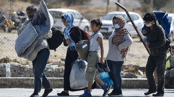 A family carrying their belongings walk toward a new temporary camp, set up to shelter refugees from the burnt Moria refugee camp, on the island of Lesbos