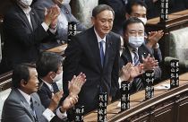 Yoshihide Suga stands up after being elected as Japan's new prime minister at parliament's lower house in Tokyo, Wednesday, Sept. 16, 2020.