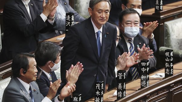 Yoshihide Suga stands up after being elected as Japan's new prime minister at parliament's lower house in Tokyo, Wednesday, Sept. 16, 2020. Yoshihide Suga stands up after being elected as Japan's new prime minister at parliament's lower house in Tokyo, Wednesday, Sept. 16, 2020.