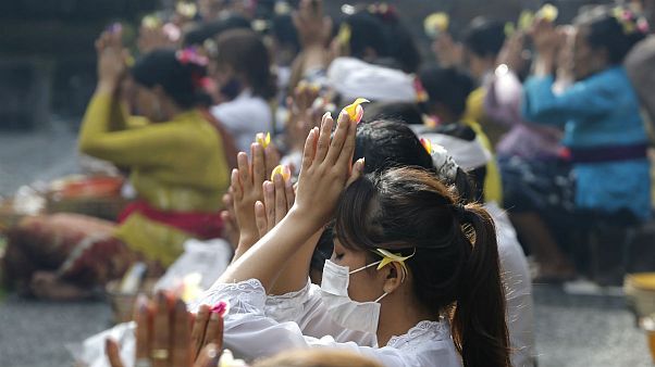 Women wearing face masks as a precaution against the new coronavirus outbreak pray during a Hindu ritual prayer at a temple in Bali, Indonesia Women wearing face masks as a precaution against the new coronavirus outbreak pray during a Hindu ritual prayer at a temple in Bali, Indonesia