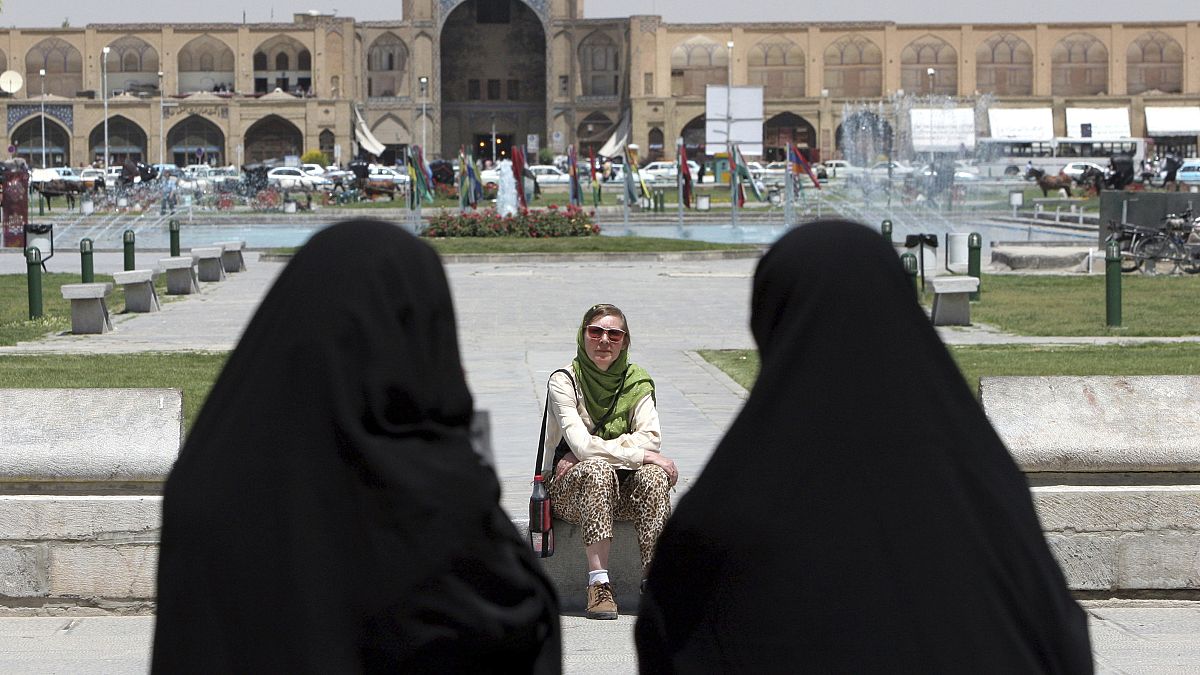 İran'ın İsfahan kentinde bir yabancı turistin önünden geçen çarşaflı İranlı kadınlar (arşiv)