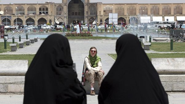 İran'ın İsfahan kentinde bir yabancı turistin önünden geçen çarşaflı İranlı kadınlar (arşiv) İran'ın İsfahan kentinde bir yabancı turistin önünden geçen çarşaflı İranlı kadınlar (arşiv)
