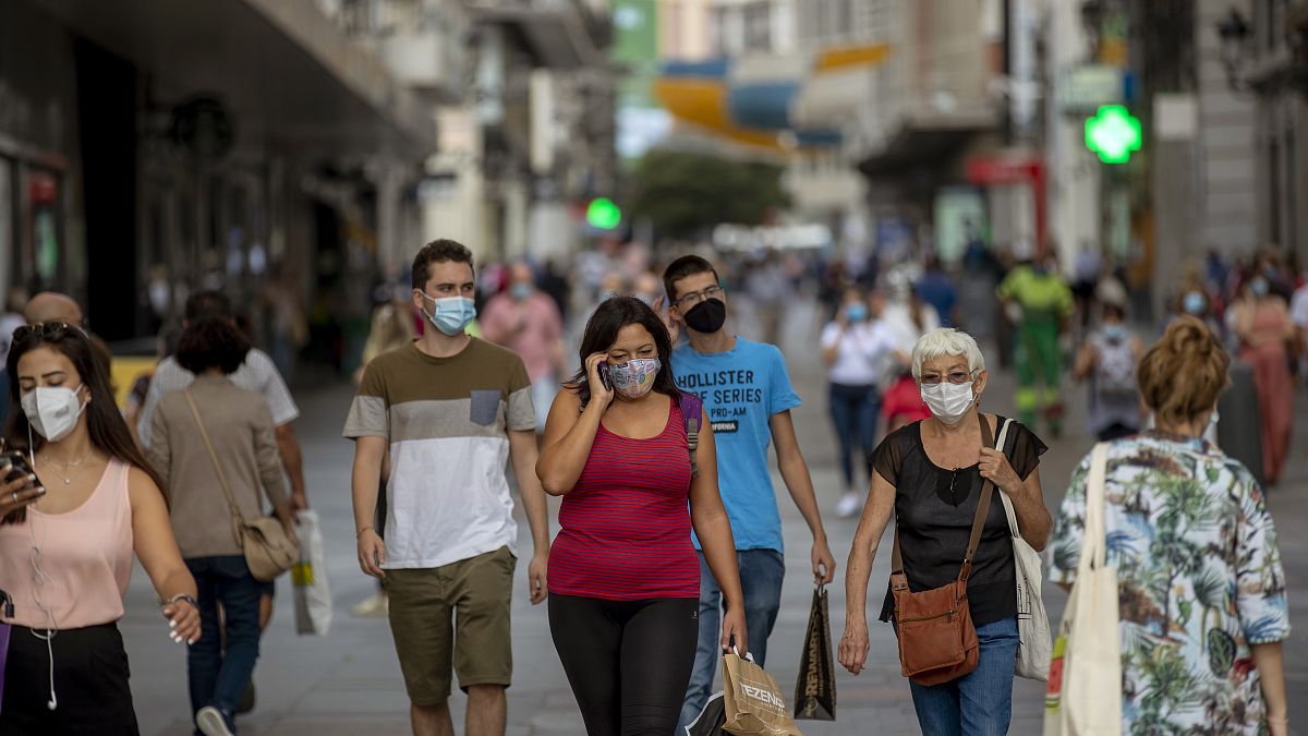 Personas con mascarilla caminan por una calle de Madrid