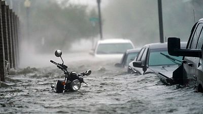 Cars and a motorcycle are underwater as water floods a street, in Pensacola, Fla., Wednesday, Sept. 16, 2020