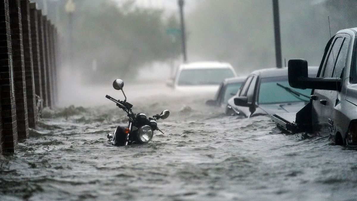 Cars and a motorcycle are underwater as water floods a street, Wednesday, Sept. 16, 2020, in Pensacola, Fla. Hurricane Sally made landfall Wednesday near Gulf Shores, Alabama.