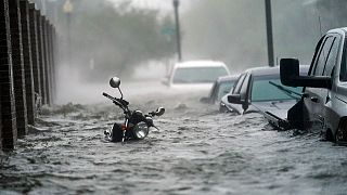 Cars and a motorcycle are underwater as water floods a street, Wednesday, Sept. 16, 2020, in Pensacola, Fla. Hurricane Sally made landfall Wednesday near Gulf Shores, Alabama.
