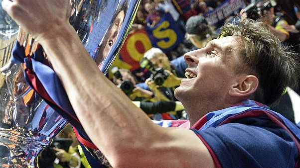 In this June 6, 2015 file photo, Barcelona's Lionel Messi smiles to his mirror in the trophy after winning the Champions League final football match against Juventus. In this June 6, 2015 file photo, Barcelona's Lionel Messi smiles to his mirror in the trophy after winning the Champions League final football match against Juventus.