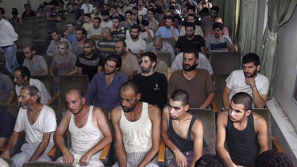 صورة من الأرشيف- معتقلون سوريون شاركوا في احتجاجات مناهضة للحكومة  في قاعة محكمة قبل إطلاق سراحهم- دمشق