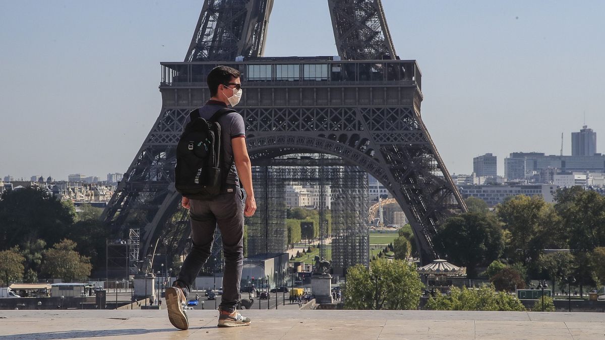 A man wearing a face mask as precaution against conoravirus walks at Trocadero plaza near Eiffel Tower in Paris.