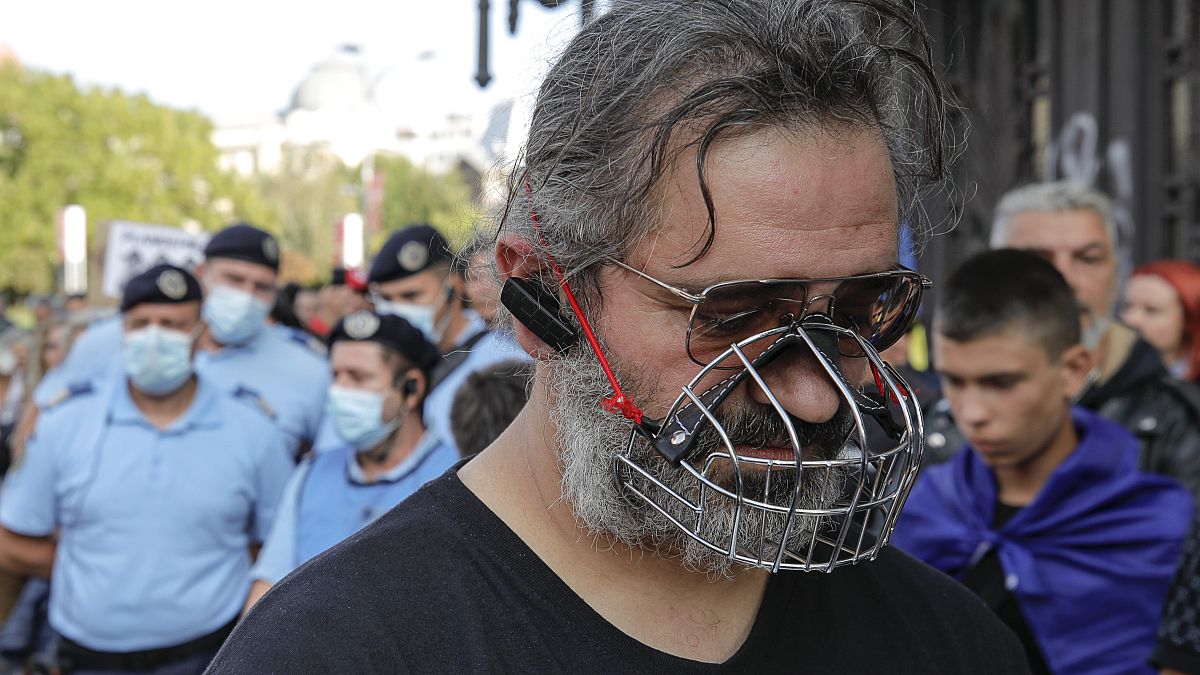 Un homme porte une muselière pendant une manifestation contre les mesures sanitaires prises dans par la Roumanie, Bucarest le 19 septembre 2020