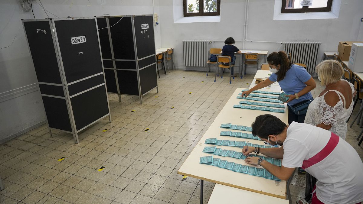 Volunteers stamp ballots at a polling station, in Rome, Saturday, Sept. 19, 2020.