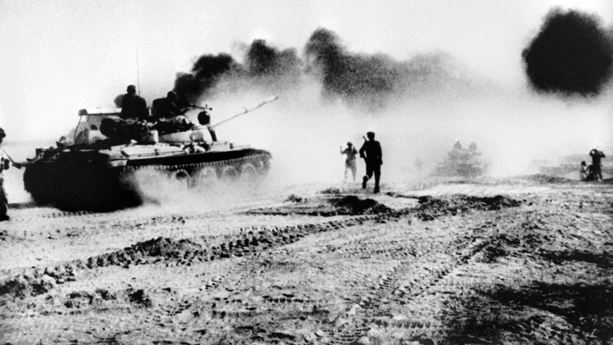 دبابات عراقية تحاول عبور نهر كارون شمال شرق خرمشهر في العراق، خلال الحرب العراقية الإيرانية، ودخان يتصاعد من أنبوب للنفط. 1980/10/22