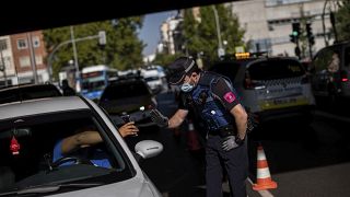 Un policía local detiene un vehículo en un control en Madrid, España