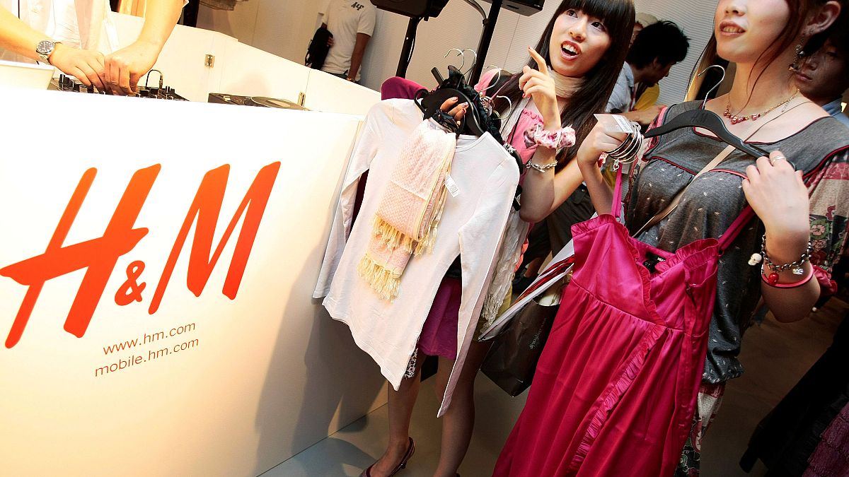 FILE: Shoppers on opening day of H&M's first Japan store in Tokyo's Ginza shopping district examine clothes, Sept. 13, 2008. 