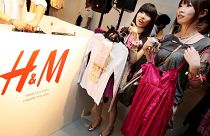FILE: Shoppers on opening day of H&M's first Japan store in Tokyo's Ginza shopping district examine clothes, Sept. 13, 2008.