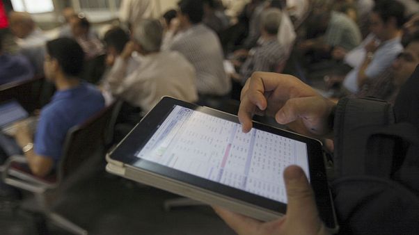 An Iranian shareholder monitors shares prices on his tablet at the Tehran Stock Exchange in Tehran, Iran An Iranian shareholder monitors shares prices on his tablet at the Tehran Stock Exchange in Tehran, Iran