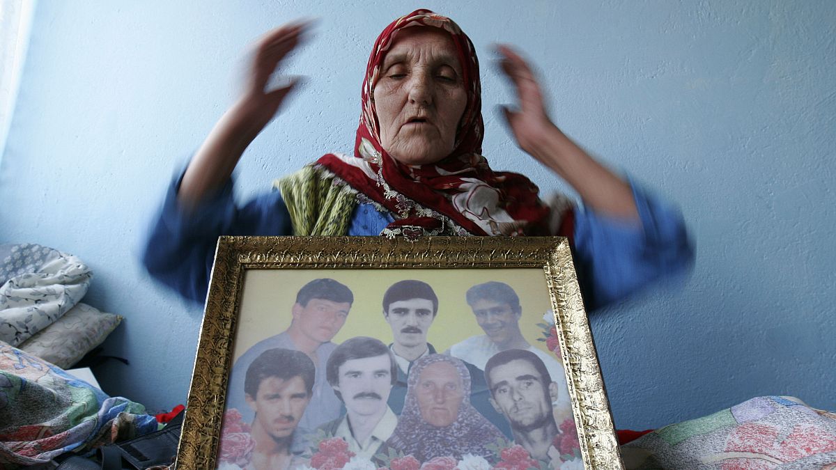 امرأة بوسنية مسلمة مع صورة لأحبائها الذين ذبحوا في واحدة من أفظع المجازر الذي عرفها التاريخ 