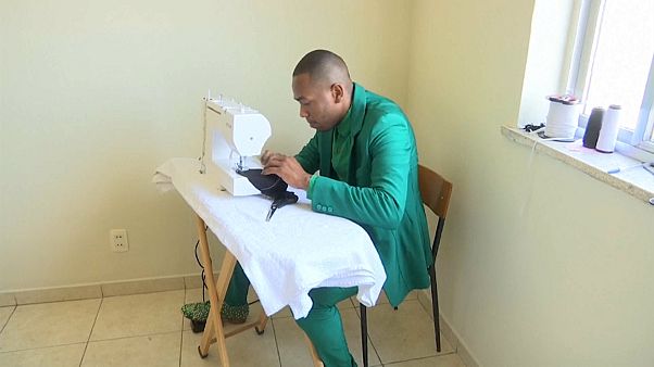 أحد الراقصين في المهرجان يعمل في خياطة الكمامات أحد الراقصين في المهرجان يعمل في خياطة الكمامات