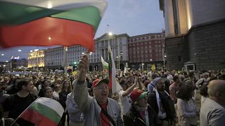 A protester shouts and holds the Bulgarian flag as protesters continue to demand the government's resignation.