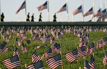 Activists from the COVID Memorial Project mark the deaths of 200,000 lives lost in the US to COVID-19 after placing thousands of small American flags in Washington DC.