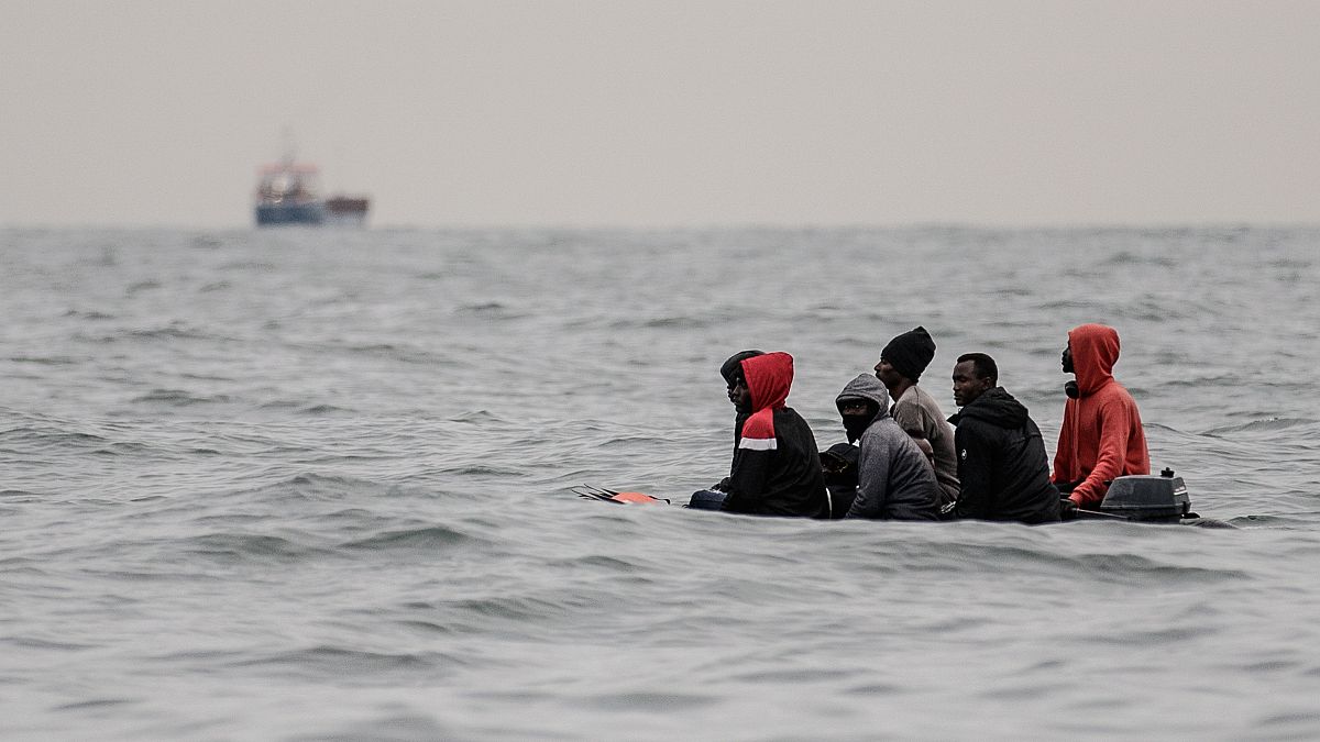 Migrants aboard a boat in rough waters in the English Channel as they attempt to cross to England