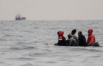 Migrants aboard a boat in rough waters in the English Channel as they attempt to cross to England
