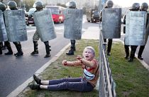 A woman reacts as she sits in front of law enforcement officers during a rally to protest against the presidential inauguration in Minsk on September 23, 2020. 